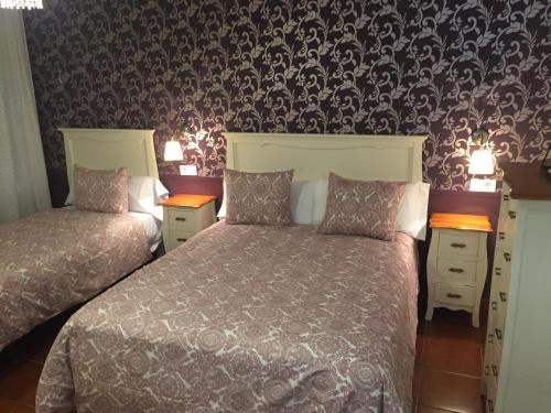 奇皮奥纳Hostal El Puerto Boutique的一间卧室设有两张床和壁纸墙