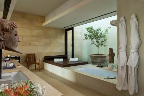 里贝拉维尔杜拉度假酒店的浴室设有大浴缸,里面有一棵树