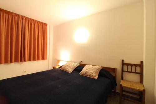 布拉内斯Apartaments El Sorrall的一间卧室设有一张黑色的床和一个窗户。