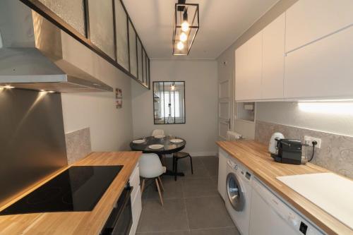 奥尔良PRESTIGELOC Appart 3 Chambres 2 SDB La Loire的厨房配有洗衣机、烘干机和桌子