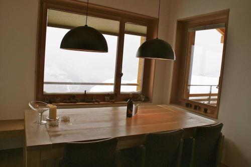 贝特默阿尔卑Perle des Alpes, Bettmeralp, Switzerland的餐桌、椅子和2个窗户