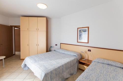 卡奥莱Robinia/Pinetine Lido Altanea的一间卧室配有两张床和橱柜
