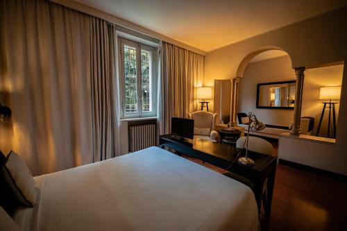 拉文纳佛里斯圣塔玛丽亚别墅酒店的一间卧室配有一张床、一张书桌和一个窗户。