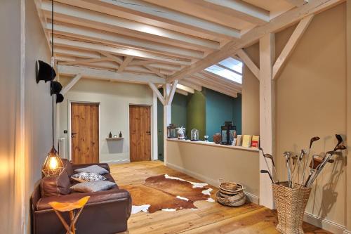 卡斯泰BEL AIR MAISON D'HOTES DES LANDES的客厅设有真皮沙发和木制天花板。