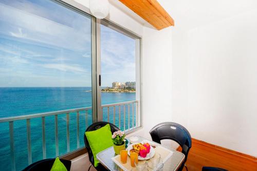 圣朱利安斯Spinola Bay top floor seafront 3 bedroom Apartment with panoramic sea views - by Getawaysmalta的阳台的桌子享有海景