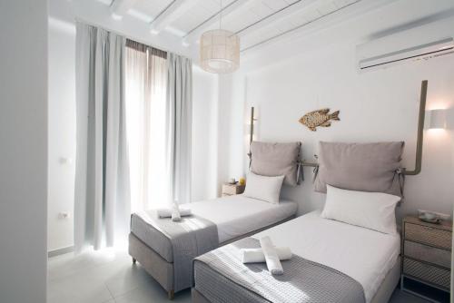 Vrisi/ MykonosDesire Mykonos Apartments的白色卧室配有两张床和椅子