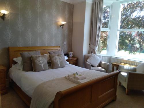 Bassenthwaite Lake里可宾馆的卧室配有床、椅子和窗户。