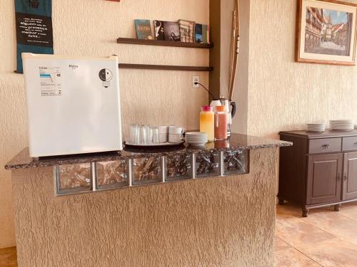 巴伊亚达特莱桑普萨达娜贝拉多玛尔酒店的厨房柜台配有冰箱和餐具。