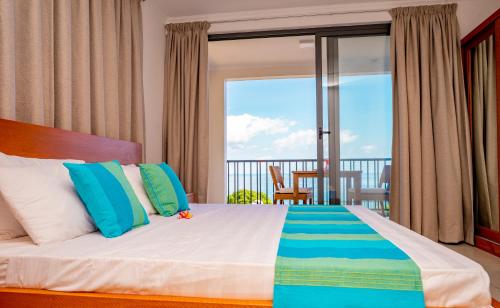 维多利亚Kolibri Holiday Apartments的一间卧室设有一张床,享有阳台的景色