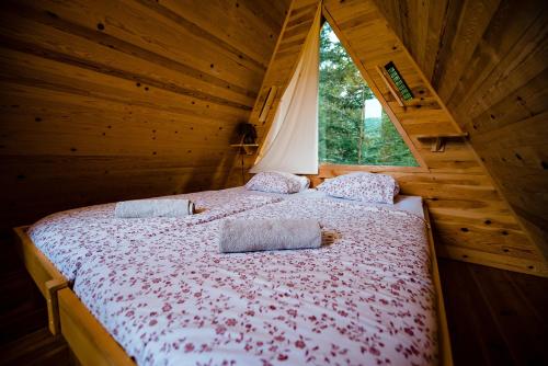 卡姆尼克Glamping FOREST EDGE的小木屋内一间卧室,配有一张床