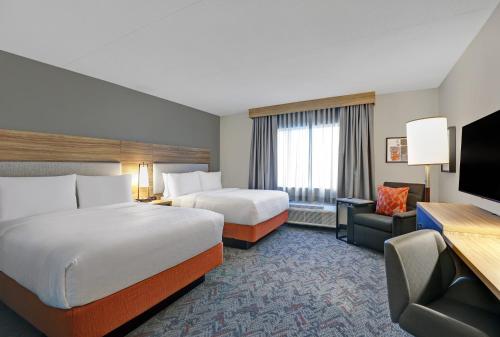 金斯顿Candlewood Suites - Kingston West, an IHG Hotel的酒店客房设有两张床和一台平面电视。