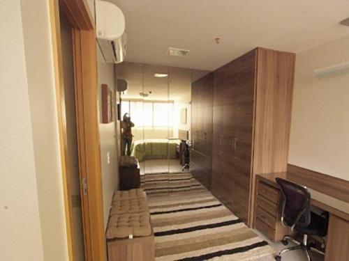 巴西利亚Duplex Apto Setor Hoteleiro Norte com serviço diário de limpeza的走廊上设有一张床和一张书桌的房间