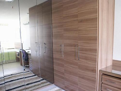 巴西利亚Duplex Apto Setor Hoteleiro Norte com serviço diário de limpeza的办公室内带玻璃门的大型木制衣柜
