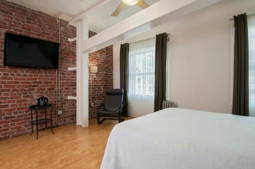 旧金山赫伯特酒店的一间卧室设有一张床和砖墙