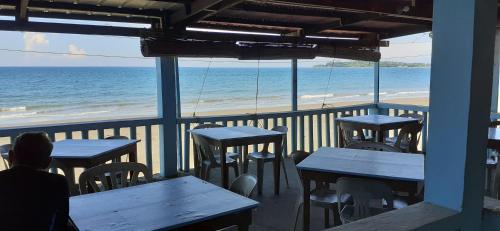 巴旺Bella's Beach Resort Apartment 8的坐在餐厅桌子旁俯瞰海滩的人