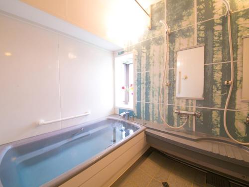 静冈ホテル盛松館的一间带大浴缸和窗户的浴室