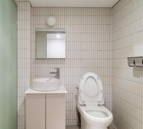 首尔上流旅馆的浴室配有白色卫生间和盥洗盆。