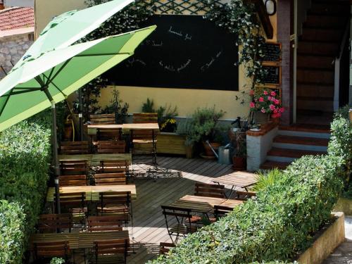圣雅内The FrogS' House - Yoga Retreat的一个带桌椅和遮阳伞的庭院