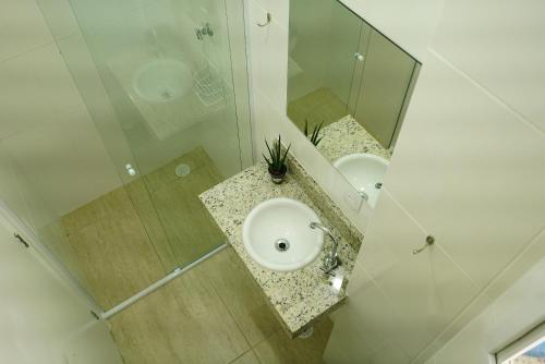 瓜鲁雅Enseada Village Guarujá的一间带水槽和镜子的浴室