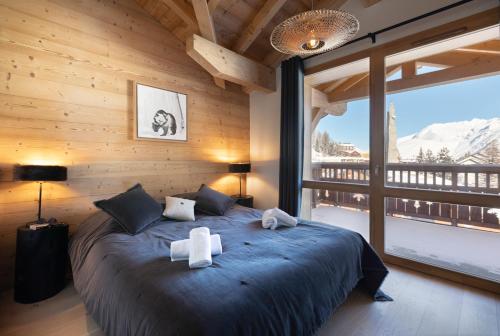 莱德萨阿尔卑斯TERRESENS - Neige et Soleil的一间卧室配有一张大床和两条毛巾