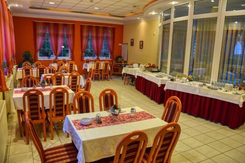 塔塔潘塔卢克斯酒店的一间设有桌椅和红色墙壁的餐厅