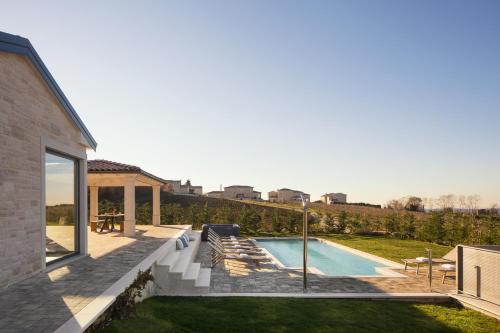 维齐纳达Villa Edoardo的一个带游泳池和房子的后院