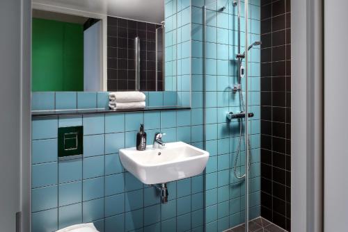 代尔夫特The Social Hub Delft的蓝色瓷砖浴室设有水槽和淋浴