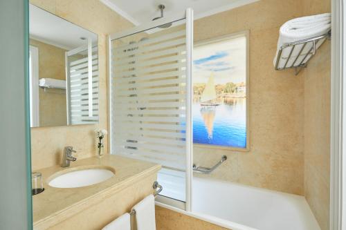 卢克索Steigenberger Resort Achti的一间带水槽、浴缸和镜子的浴室