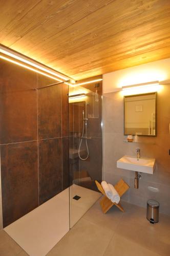 韦尔米廖Albergo Alpino的带淋浴和盥洗盆的浴室