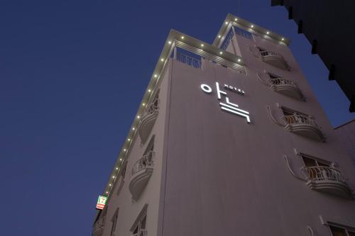 大田Aank Hotel Daejeon Yongjeon 1的一座高大的建筑,旁边是钟