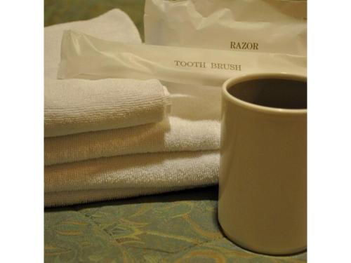 东京Hotel Suntargas Ueno - Vacation STAY 08474v的一堆毛巾和桌上的咖啡杯