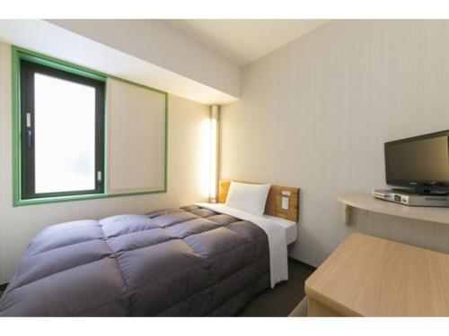 横滨R&B Hotel Shin Yokohama Ekimae - Vacation STAY 14693v的配有一张床和一台平面电视的酒店客房