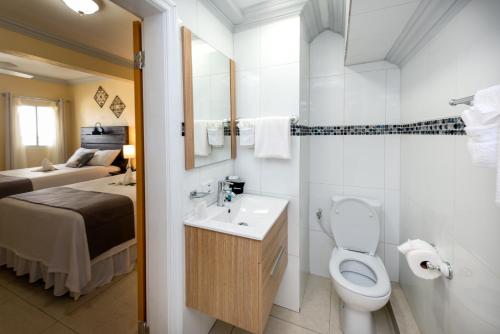 辛普森湾贝克套房酒店的一间带卫生间、水槽和床的浴室
