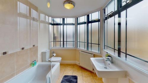 布伦特里Niche Water Tower Apartments的一间带水槽、浴缸和卫生间的浴室