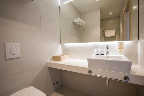 斯拉诺Hotel Osmine的白色的浴室设有水槽和镜子