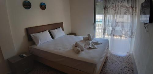 帕拉利亚狄奥尼索Zoi Apartments的一间卧室配有带毛巾的床和窗户。