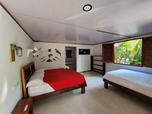 格兰德岛Isla Grande Eco-Hostal的一间卧室设有两张床和窗户。