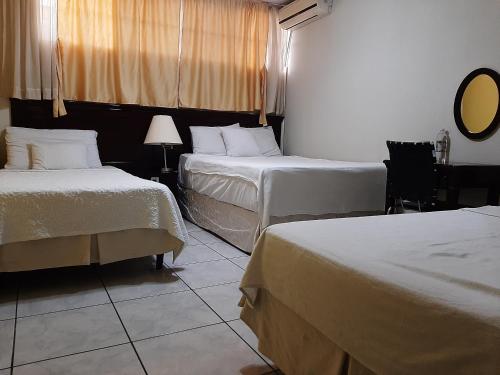 圣萨尔瓦多圣何塞旅馆的酒店客房,设有两张床和镜子