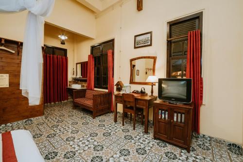 大叻沙非大叻酒店的客厅配有电视、书桌和书桌。