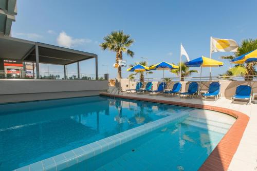 罗希姆诺玛里琳公寓式酒店的一个带蓝色椅子和遮阳伞的游泳池