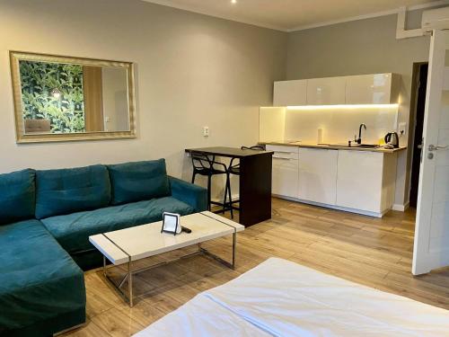 卡托维兹Apartmenty Mariacka 20 -Self Check-In 24h -Loud on the weekends - by Kanclerz Investment的带沙发和桌子的客厅以及厨房。