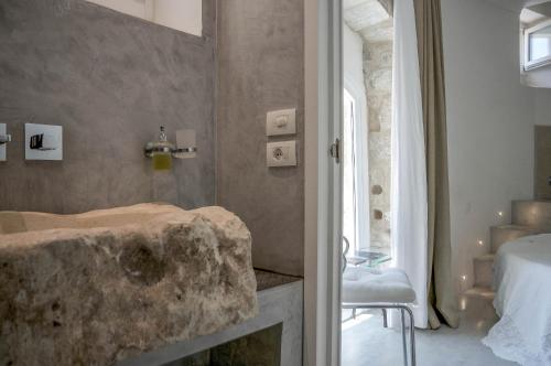 莫迪卡Anime a Sud - Residenza Hortus的一间带石质水槽和床的浴室
