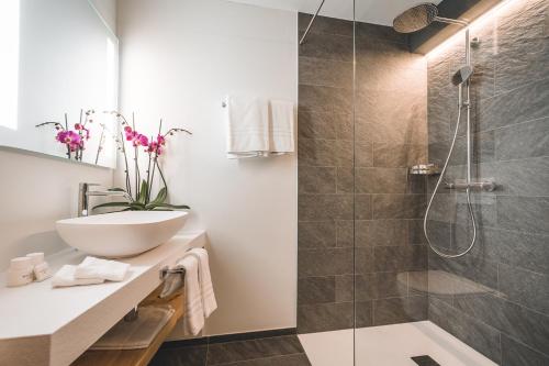 圣莫里茨劳迪内拉酒店的一间带水槽和淋浴的浴室
