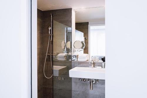 布鲁塞尔Pillows City Hotel Brussels Centre的浴室设有水槽和带镜子的淋浴