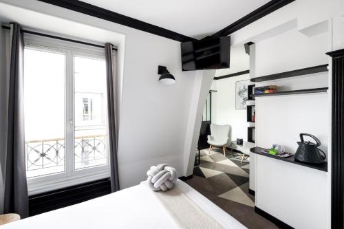 巴黎牧歌度假屋的一间小公寓,拥有白色的墙壁和大窗户