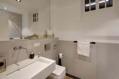弗莱堡Boutique Apartments Freiburg - Eva的白色的浴室设有水槽和卫生间。