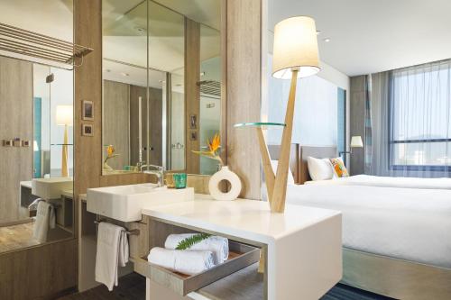 台东Hotel Cham Cham Taitung Caesar Park Hotels & Resort的一间带水槽的浴室和一张位于客房内的床