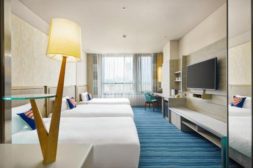台东Hotel Cham Cham Taitung Caesar Park Hotels & Resort的酒店客房设有四张床和平面电视。