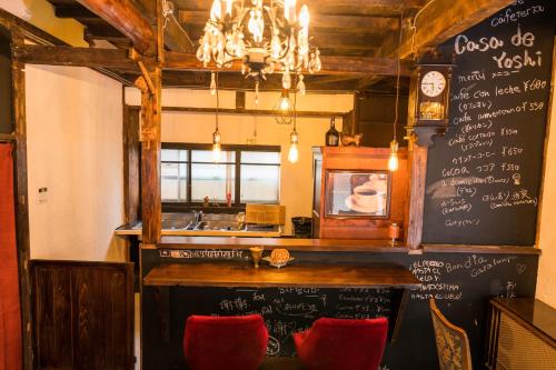 山形市CASA DE YOSHi 一棟貸し的餐厅设有酒吧,配有粉笔板墙