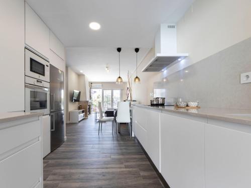 库尼特Holiday Home Aeris by Interhome的厨房配有白色橱柜和长柜台。